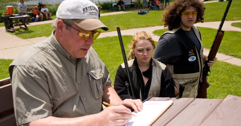 Young people watching an older man keep score.